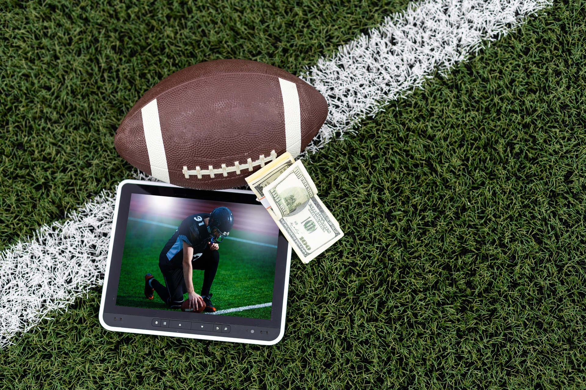 American football app video game on smartphone.. Mobile phone and american football ball and helmet isolated on white. 3d illustration